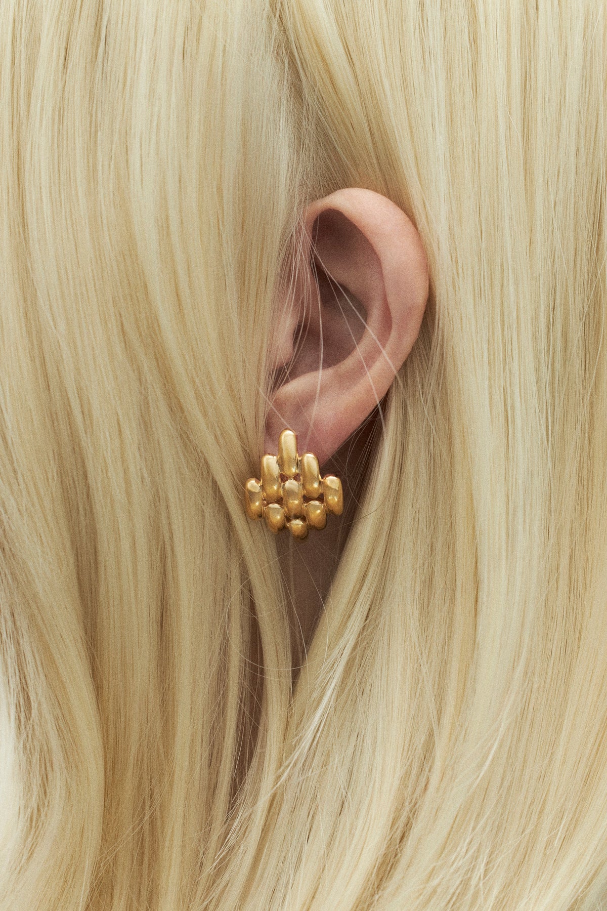 Gold earrings worn by a blonde woman, perfect wedding guest earrings.