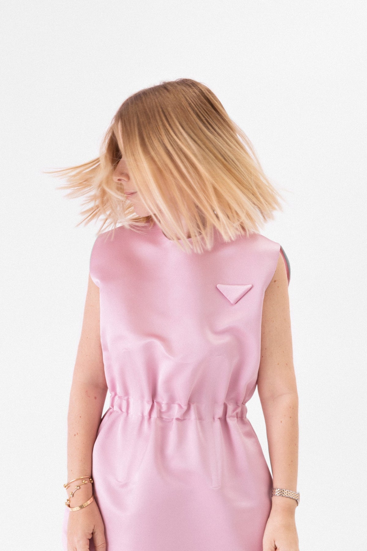 Mulheres que Moldaram a Joalharia: modelo em vestido rosa com cabelo ao vento.