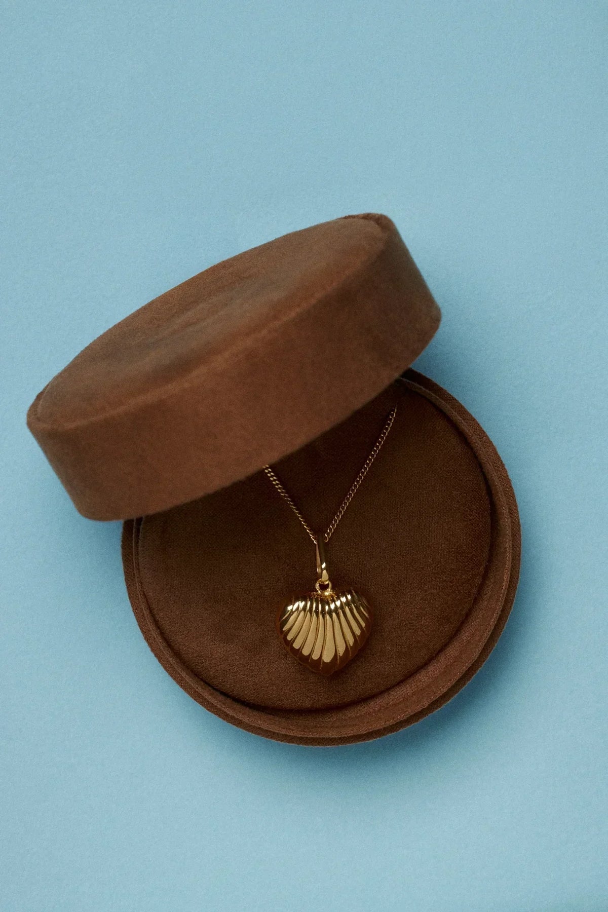joia oferecer num noivado civil - necklace in a brown jewelry box on a blue background.
