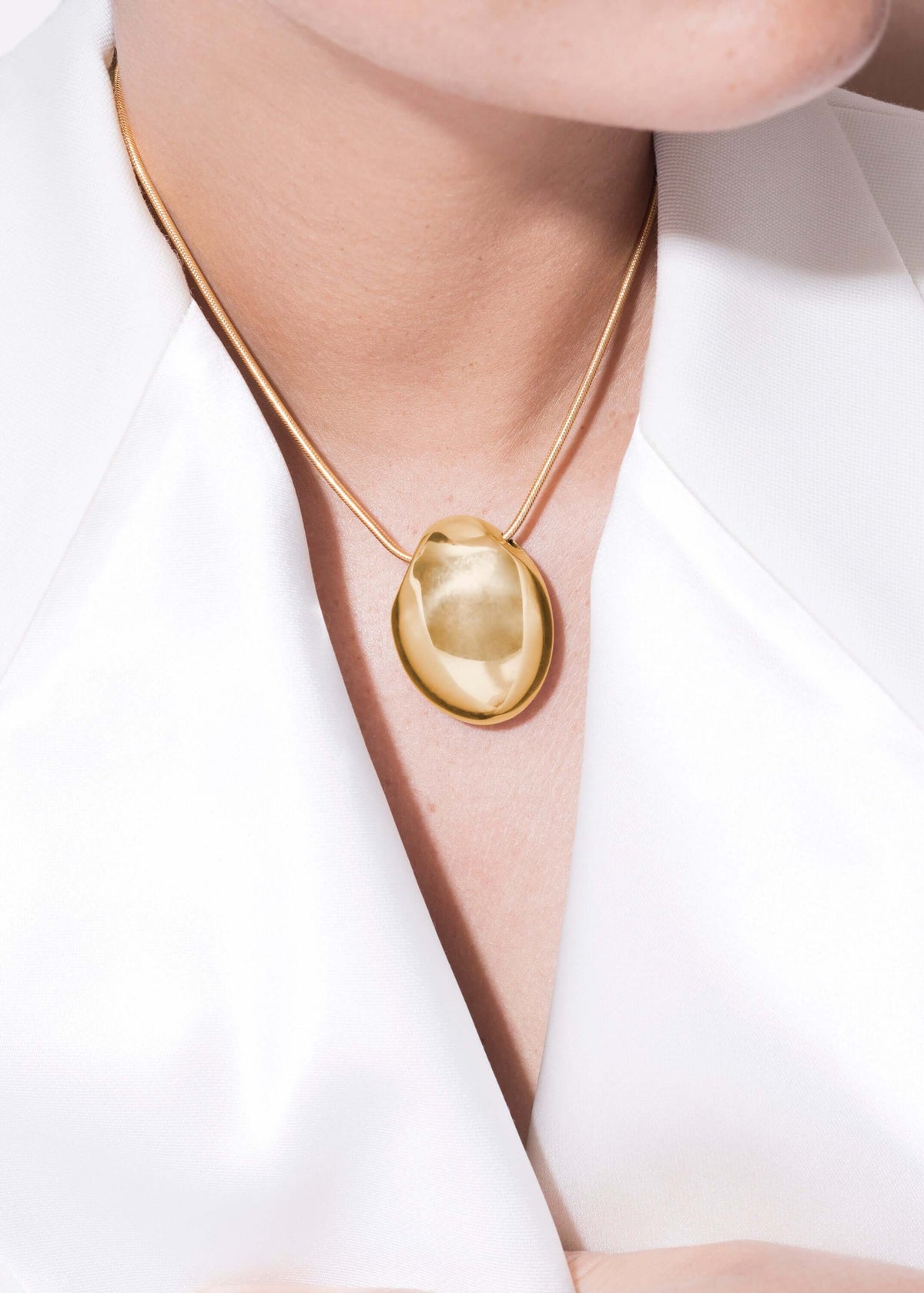 Handmade elegant Chéri necklace displayed on a model against a white background, highlighting its unique pendant design.