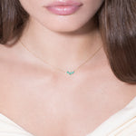 model wearing emerald and diamond 18k necklace