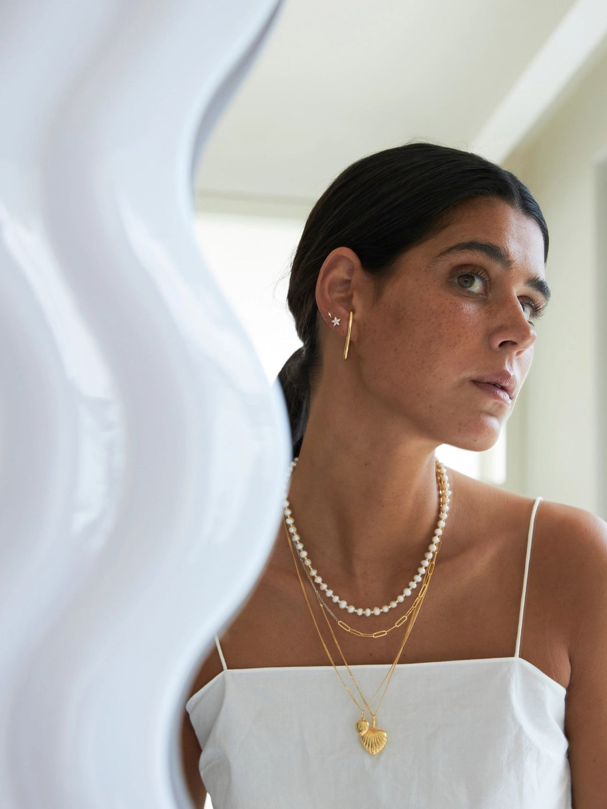 Close-up of a woman wearing layered necklaces showcasing personalized jewelry gifts and their significance.