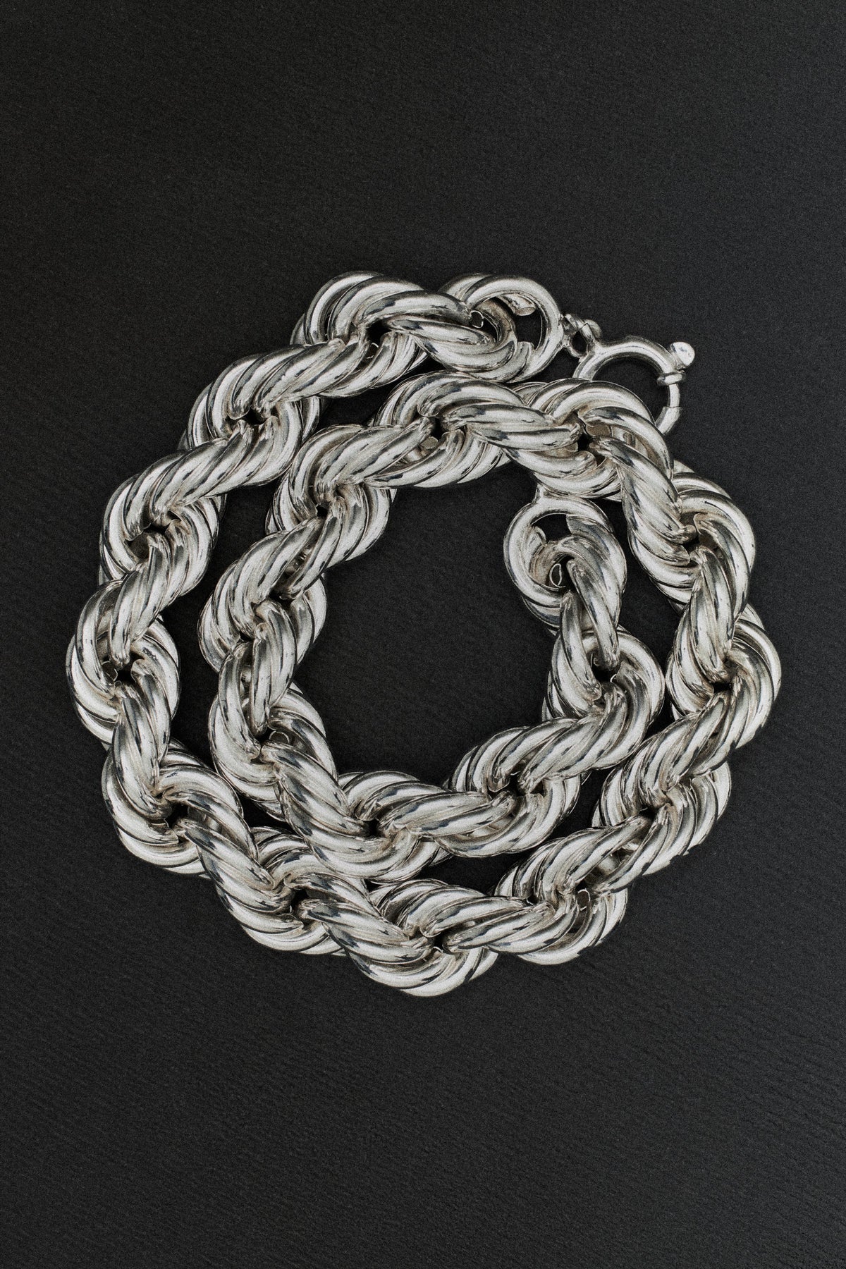 sterling silver chain necklaces featuring twisted links on a black background.