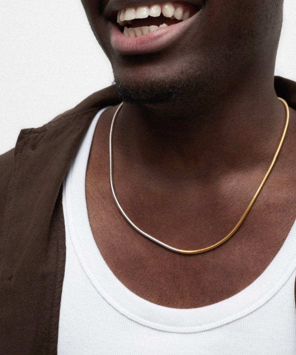 Close-up of a man wearing a silver and gold chain necklace, showcasing men's sterling silver necklaces.