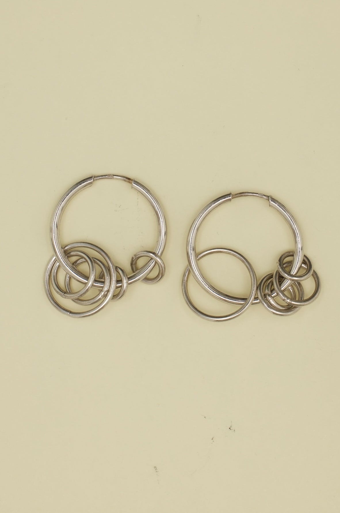 Pair of silver hoop earrings on a beige background
