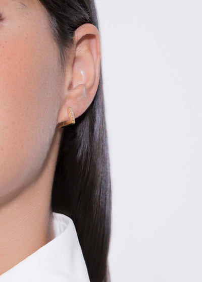 Close-up of a model wearing a topaz triangle hoop earring, showcasing its unique design and craftsmanship.