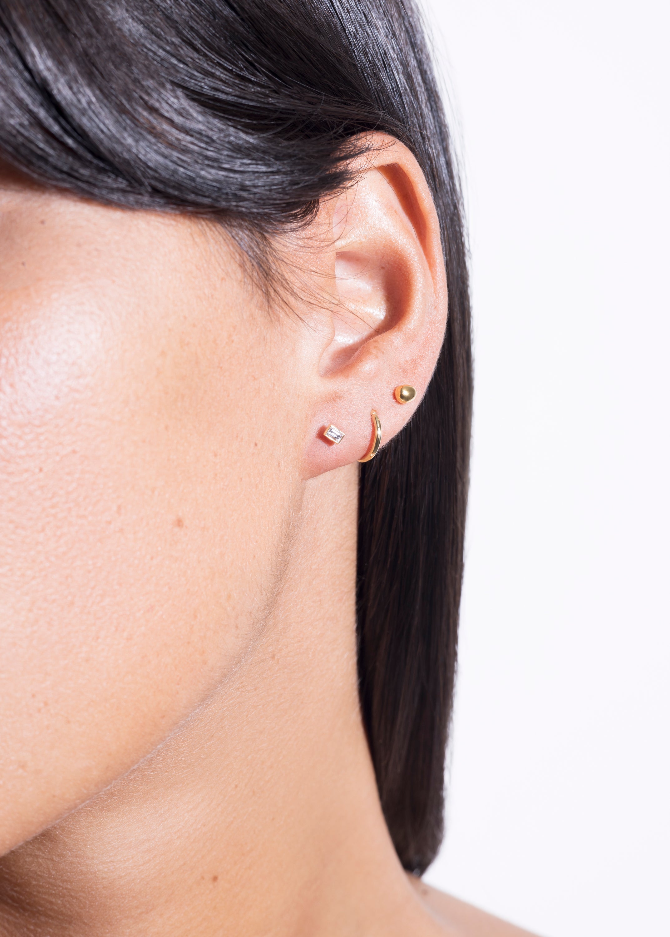 model wearing (non)sphere earrings 18k, seamless hoop 18k and earring starter 08 diamond