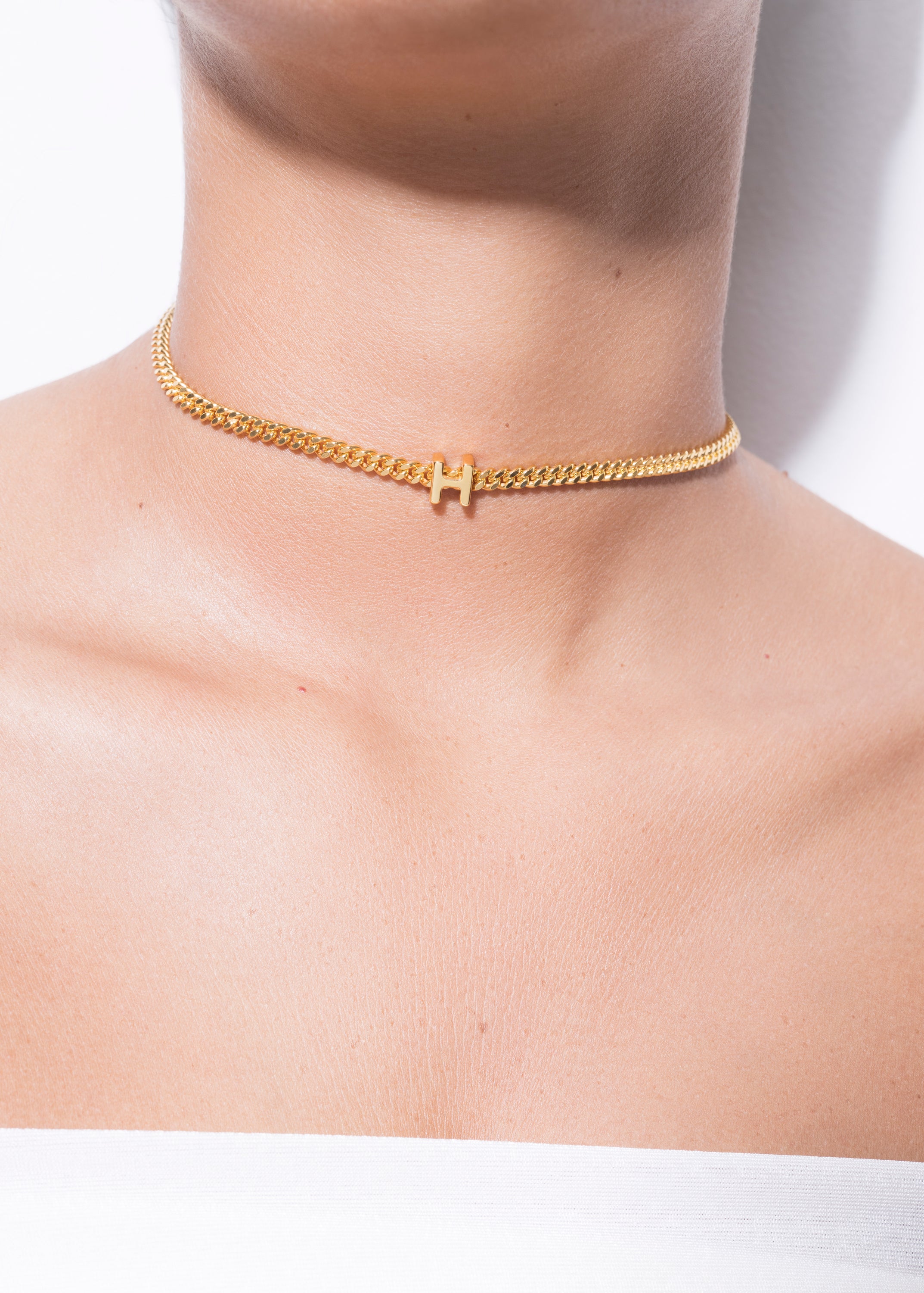 model wearing alphabet necklace with pendant H in gold