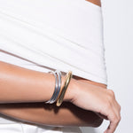 model wearing colette bracelet in gold and arlo bracelet and little arlo bracelet in silver