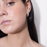 model wearing harpa earrings in silver