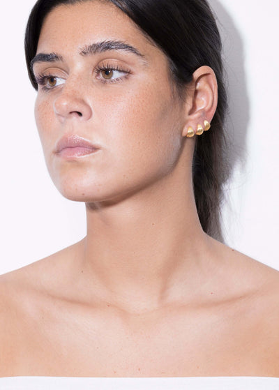 Model showcasing Tilly huggie earrings silver gold on her ear, highlighting their elegant design and close fit.